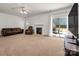Cozy living room featuring a fireplace, ceiling fan and sliding glass doors to the patio at 12802 Waterlyn Club Dr, Charlotte, NC 28278