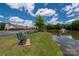 Scenic pond view with a fountain, benches, and picnic tables, creating a relaxing outdoor space within the community at 12802 Waterlyn Club Dr, Charlotte, NC 28278