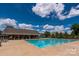Community pool featuring clear blue water, poolside seating, and a shaded pavilion, offering a refreshing and social atmosphere at 12802 Waterlyn Club Dr, Charlotte, NC 28278