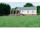 Large grassy backyard featuring covered deck space on a well-maintained lawn at 135 Meadow Lake Dr, Salisbury, NC 28146
