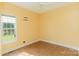 This bedroom features light yellow walls, a ceiling fan, and a window with a view of the front yard at 135 Meadow Lake Dr, Salisbury, NC 28146