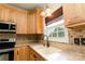 Bright kitchen features wood cabinets, stainless steel appliances, and a double bowl sink by a window at 135 Meadow Lake Dr, Salisbury, NC 28146