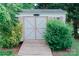 Storage shed on a concrete path with wooden doors, next to some shrubbery at 135 Meadow Lake Dr, Salisbury, NC 28146