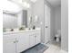 Bright bathroom featuring double sinks, white cabinets, and a large mirror at 13612 Bolingbrook Ln, Charlotte, NC 28273