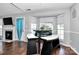 Cozy breakfast nook with bay windows, a modern table set, and hardwood floors next to the fireplace at 13612 Bolingbrook Ln, Charlotte, NC 28273