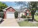 Charming brick and siding home featuring a well-manicured front yard and attached garage at 13612 Bolingbrook Ln, Charlotte, NC 28273