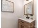 Stylish powder room featuring modern sink and faucet and artwork at 1422 Burnley Rd, Charlotte, NC 28210