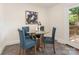Charming dining area features seating for four around a glass-top table with stylish blue chairs at 1422 Burnley Rd, Charlotte, NC 28210