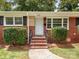 Close up of front door with brick steps and established landscaping at 1422 Burnley Rd, Charlotte, NC 28210