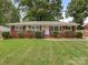 Charming single-story brick home with manicured lawn and mature trees at 1422 Burnley Rd, Charlotte, NC 28210
