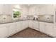 Bright kitchen with white cabinets, tile backsplash, and stainless steel dishwasher at 1422 Burnley Rd, Charlotte, NC 28210