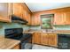 Close-up of kitchen featuring wood cabinets, laminate countertops, and black range at 154 Seven Oaks Ln, Statesville, NC 28677