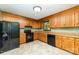 Functional kitchen with wood cabinetry, laminate countertops, and black appliances at 154 Seven Oaks Ln, Statesville, NC 28677