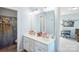 Bright bathroom featuring double sinks with a white vanity and decorative accents at 16038 Harbor Hill Dr, Charlotte, NC 28273