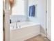 Bathroom showcasing a soaking tub with decorative tile surround and a chrome faucet at 16038 Harbor Hill Dr, Charlotte, NC 28273