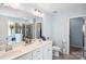 Bright bathroom with double sinks, white cabinetry, and a doorway leading to another room at 16038 Harbor Hill Dr, Charlotte, NC 28273