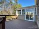 Spacious back deck with railings, offering a peaceful view of the surrounding trees and a screened-in porch at 16446 Doves Canyon Ln, Charlotte, NC 28278
