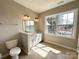 A full bathroom with a double vanity, a toilet, and a window allowing natural light at 16446 Doves Canyon Ln, Charlotte, NC 28278