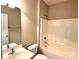 Functional bathroom featuring a vanity with sink, a toilet, and a combined tub and shower with a white tile surround at 16446 Doves Canyon Ln, Charlotte, NC 28278