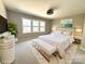 A staged bedroom with a large bed, a fluffy rug, and a view from the window at 16446 Doves Canyon Ln, Charlotte, NC 28278