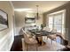 Elegant dining room with a modern chandelier, a black and gold table set for six, and a decorative buffet at 16446 Doves Canyon Ln, Charlotte, NC 28278