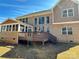 The back exterior of this brick home features a sunroom, deck, and large windows for natural light at 16446 Doves Canyon Ln, Charlotte, NC 28278