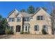 Beautiful two-story brick home with a manicured lawn and charming architectural details, including shutters and a bay window at 16446 Doves Canyon Ln, Charlotte, NC 28278