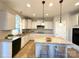 Well-lit kitchen featuring an island with seating, granite countertops, stainless steel appliances, and custom cabinetry at 16446 Doves Canyon Ln, Charlotte, NC 28278