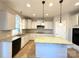 Well-lit kitchen featuring an island with seating, granite countertops, stainless steel appliances, and custom cabinetry at 16446 Doves Canyon Ln, Charlotte, NC 28278