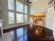 Cozy living room with hardwood floors, a fireplace, lots of windows, and an open view to the kitchen at 16446 Doves Canyon Ln, Charlotte, NC 28278