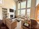 Spacious living room with a fireplace, built-in shelving, and large windows offering scenic outdoor views at 16446 Doves Canyon Ln, Charlotte, NC 28278