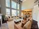 Comfortable living room showcasing high ceilings, a fireplace, hardwood floors, and access to the kitchen area at 16446 Doves Canyon Ln, Charlotte, NC 28278