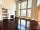 Inviting living room with hardwood floors, a cozy fireplace, built-in shelves, and expansive windows for natural light at 16446 Doves Canyon Ln, Charlotte, NC 28278