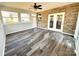 Bright sunroom features brick walls, wood-look floors, and ample natural light through large windows and French doors at 16446 Doves Canyon Ln, Charlotte, NC 28278