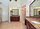 Bright bathroom showcasing double granite vanity, tile flooring, and large vanity mirror at 16511 Bridgehampton Club Dr, Charlotte, NC 28277