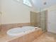 Bathroom featuring a large bathtub, glass shower, and soaking tub at 16511 Bridgehampton Club Dr, Charlotte, NC 28277