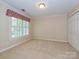 This bedroom offers neutral carpet, closet doors, and a window with white shutters at 16511 Bridgehampton Club Dr, Charlotte, NC 28277