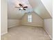 Upstairs bedroom with neutral carpet, vaulted ceilings, and a window for natural light at 16511 Bridgehampton Club Dr, Charlotte, NC 28277