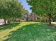 This two-story brick home features a well manicured lawn and mature trees in a lush front yard at 16511 Bridgehampton Club Dr, Charlotte, NC 28277