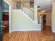 Bright foyer featuring hardwood floors, a staircase, and a view to the living room at 16511 Bridgehampton Club Dr, Charlotte, NC 28277