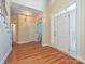 Inviting foyer featuring gleaming hardwood floors, a white front door, and stairway access at 16511 Bridgehampton Club Dr, Charlotte, NC 28277