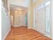 Inviting foyer with hardwood floors, staircase, and natural light pouring through the front door at 16511 Bridgehampton Club Dr, Charlotte, NC 28277