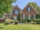 Beautiful brick home featuring a well-manicured lawn and vibrant green shrubbery at 16511 Bridgehampton Club Dr, Charlotte, NC 28277