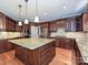 Spacious kitchen featuring a large island with a granite countertop, stainless steel appliances, and custom cabinetry at 16511 Bridgehampton Club Dr, Charlotte, NC 28277