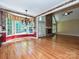 Open living room showcasing hardwood floors, many windows, a chandelier and a stunning stone fireplace at 16511 Bridgehampton Club Dr, Charlotte, NC 28277