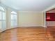 Spacious living room featuring hardwood floors, crown molding, and natural light from the large windows at 16511 Bridgehampton Club Dr, Charlotte, NC 28277