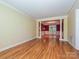 Expansive living room featuring hardwood floors, crown molding, and an open design to the dining area at 16511 Bridgehampton Club Dr, Charlotte, NC 28277