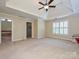 Spacious main bedroom features neutral carpet, a tray ceiling, a window, and an ensuite bathroom at 16511 Bridgehampton Club Dr, Charlotte, NC 28277