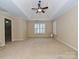 Spacious main bedroom with a tray ceiling, neutral carpeting, and a large window at 16511 Bridgehampton Club Dr, Charlotte, NC 28277