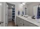 Bathroom features double sinks with white countertops, vanity, and shower with curtained tub at 17513 Julees Walk Ln, Davidson, NC 28036